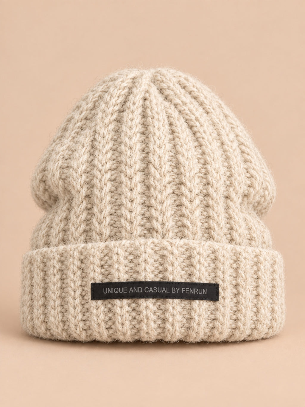 Bonnet beige en maille épaisse à revers et étiquette, vue de face.