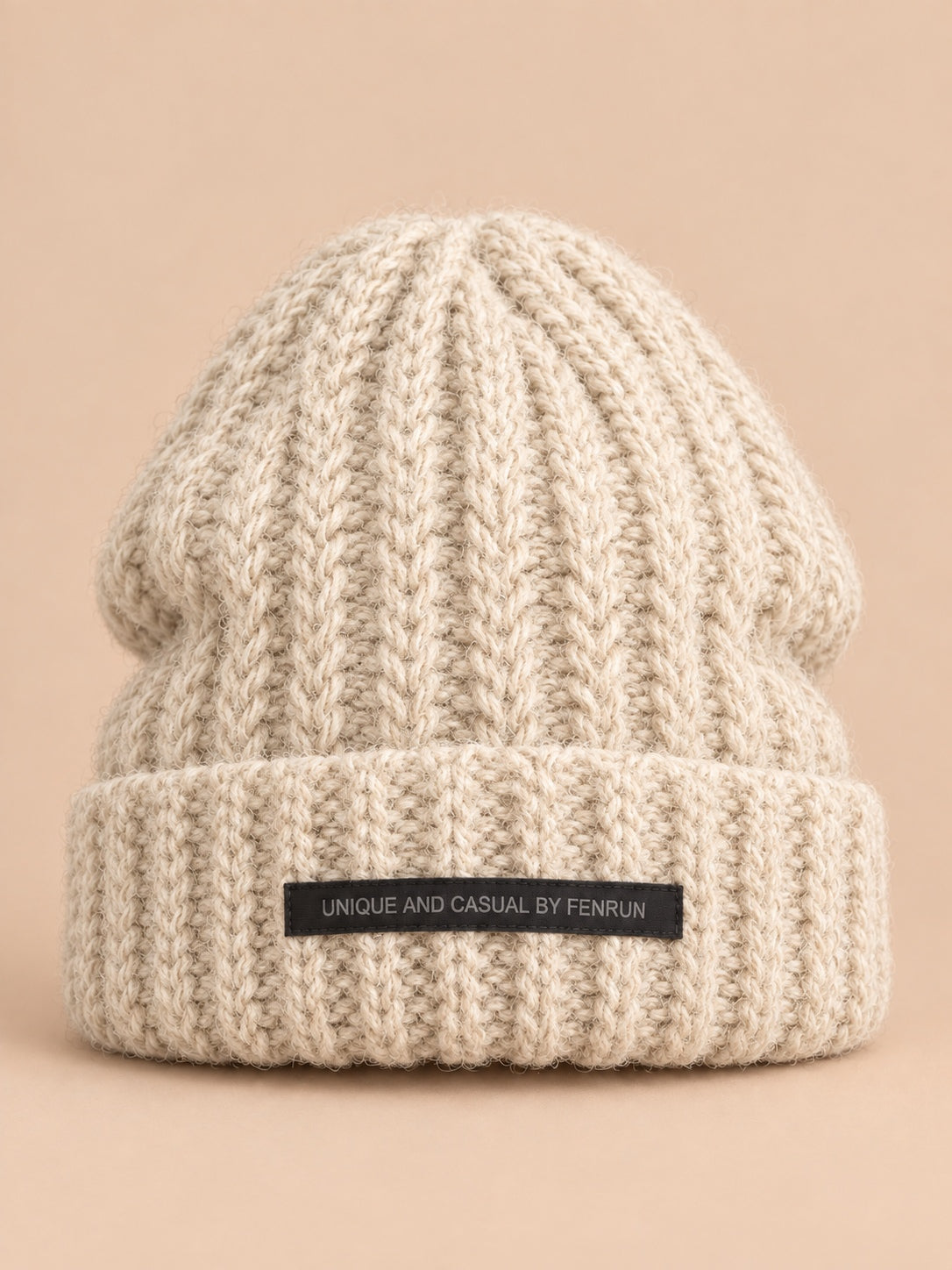 Bonnet beige en maille épaisse à revers et étiquette, vue de face.