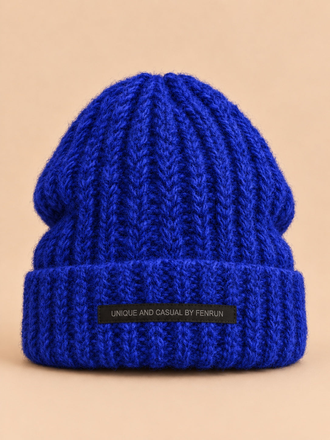 Bonnet bleu en maille épaisse à revers et étiquette, vue de face.