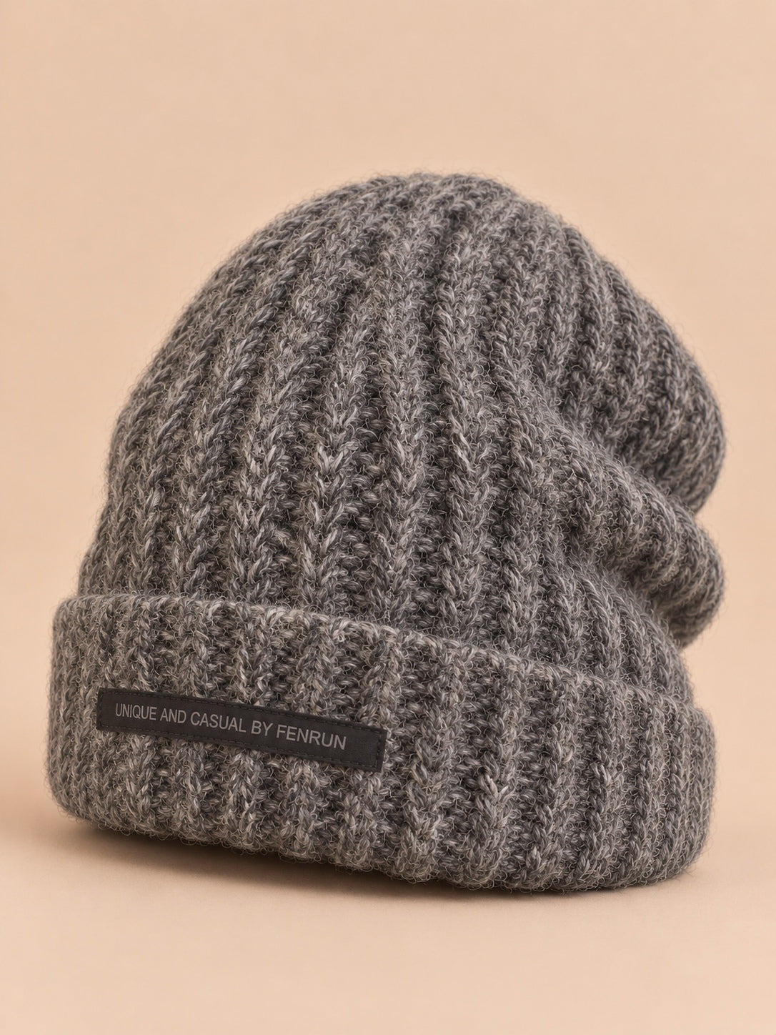 Bonnet gris en maille épaisse à revers et étiquette, vue de trois quarts.