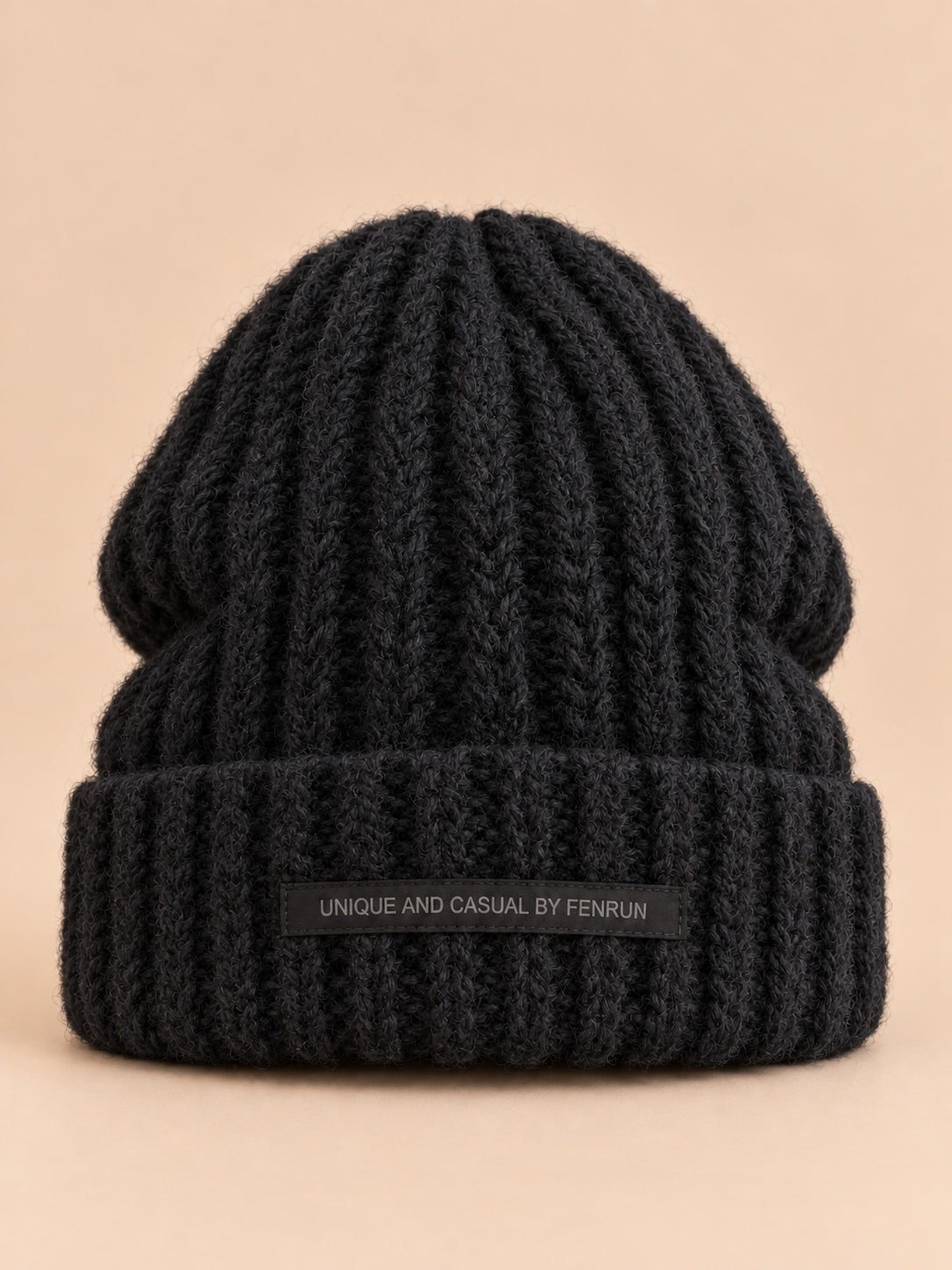 Bonnet noir en maille épaisse à revers et étiquette, vue de face.