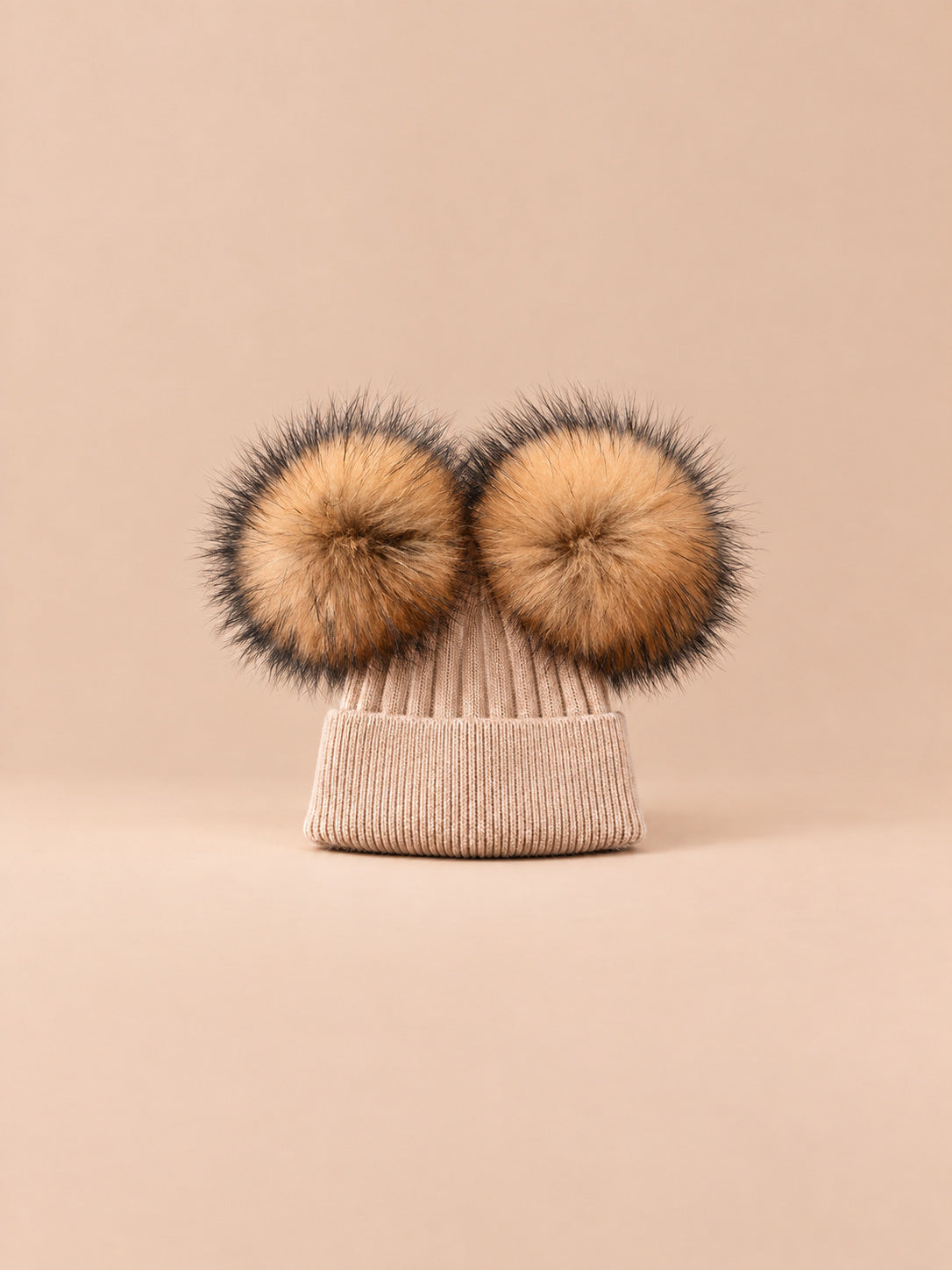 Bonnet double pompon, kaki, pompons assortis, vue de face sur fond pêche sable.