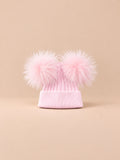 Bonnet double pompon, rose, pompons assortis, vue de face sur fond pêche sable.