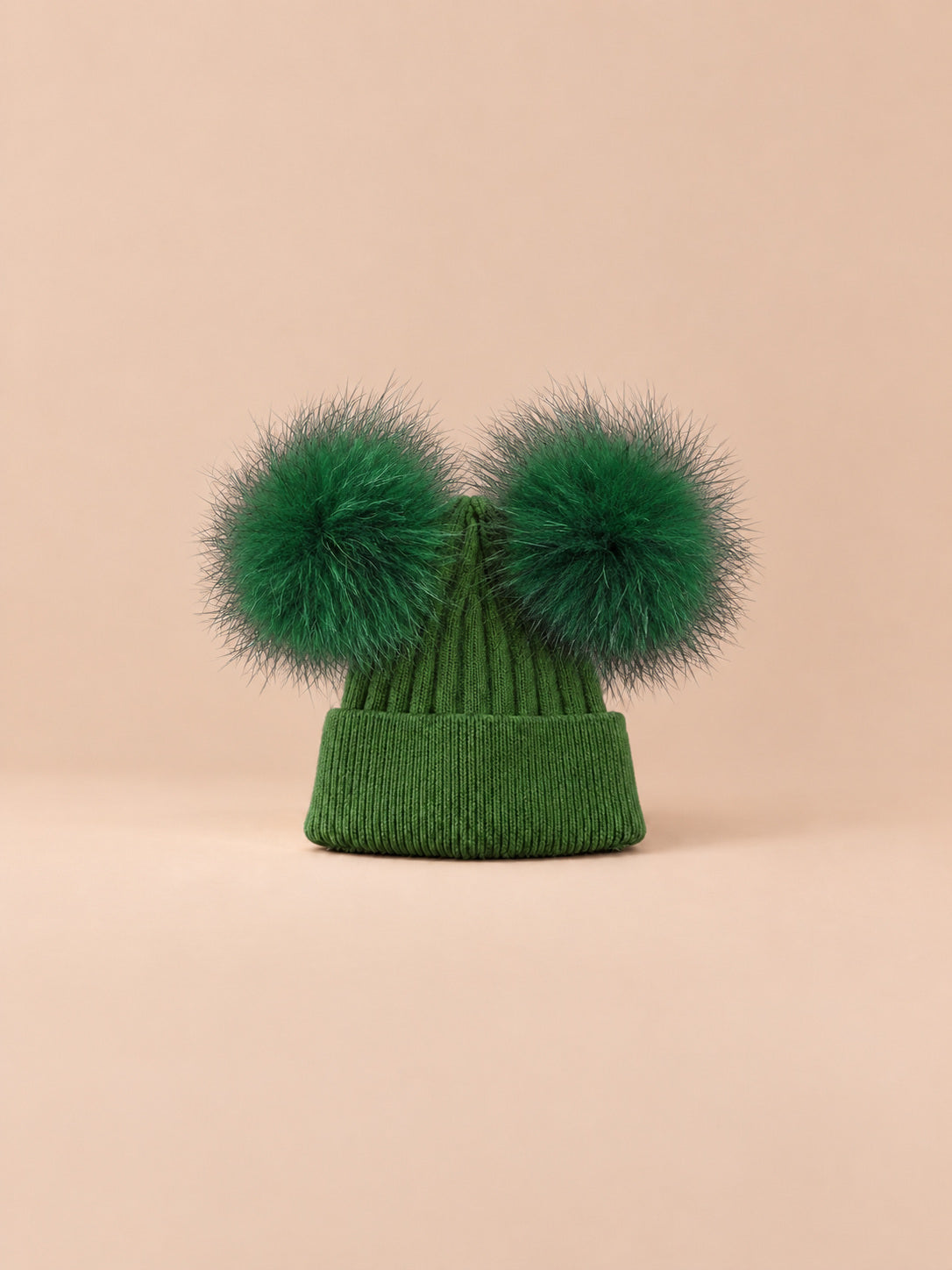 Bonnet double pompon, vert, pompons assortis, vue de face sur fond pêche sable.