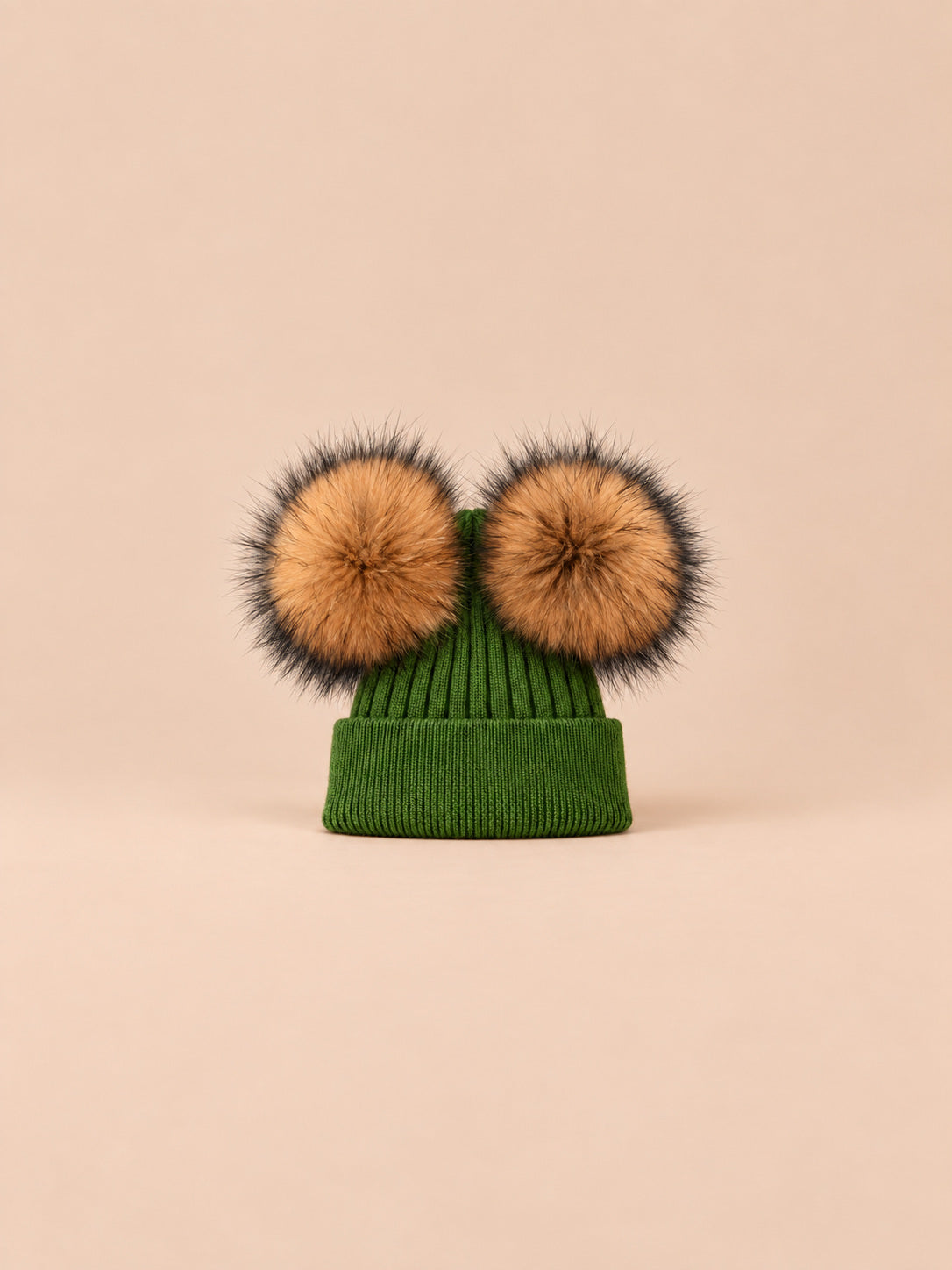 Bonnet double pompon, vert, pompons naturels, vue de face sur fond pêche sable.