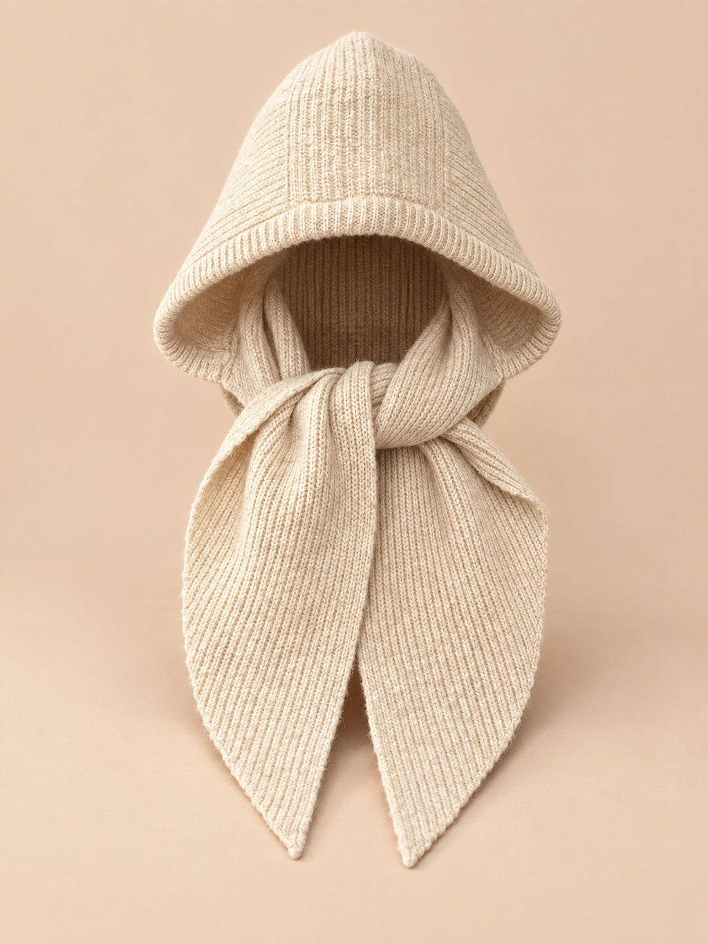Cagoule bonnet-écharpe beige en maille, vue de face sur fond pêche sable