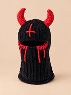 Cagoule crochet cornes de diable modèle 3 noire et rouge, vue de face sur fond pêche sable