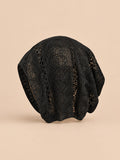 Bonnet calotte froncée noir en dentelle crochet ajourée, vue de face sur fond pêche sable