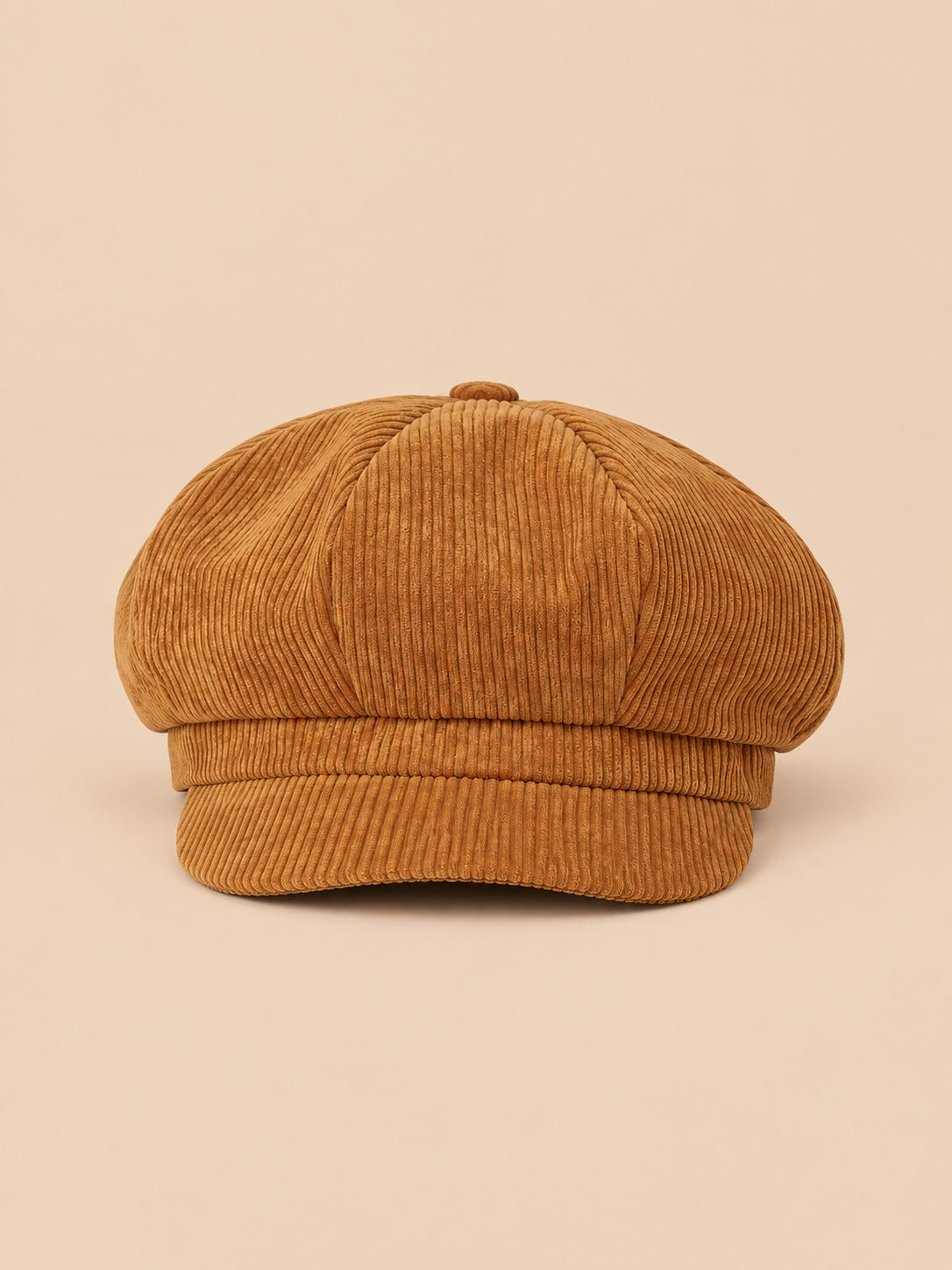 Casquette gavroche octogonale en velours côtelé jaune, vue de face sur fond pêche sable