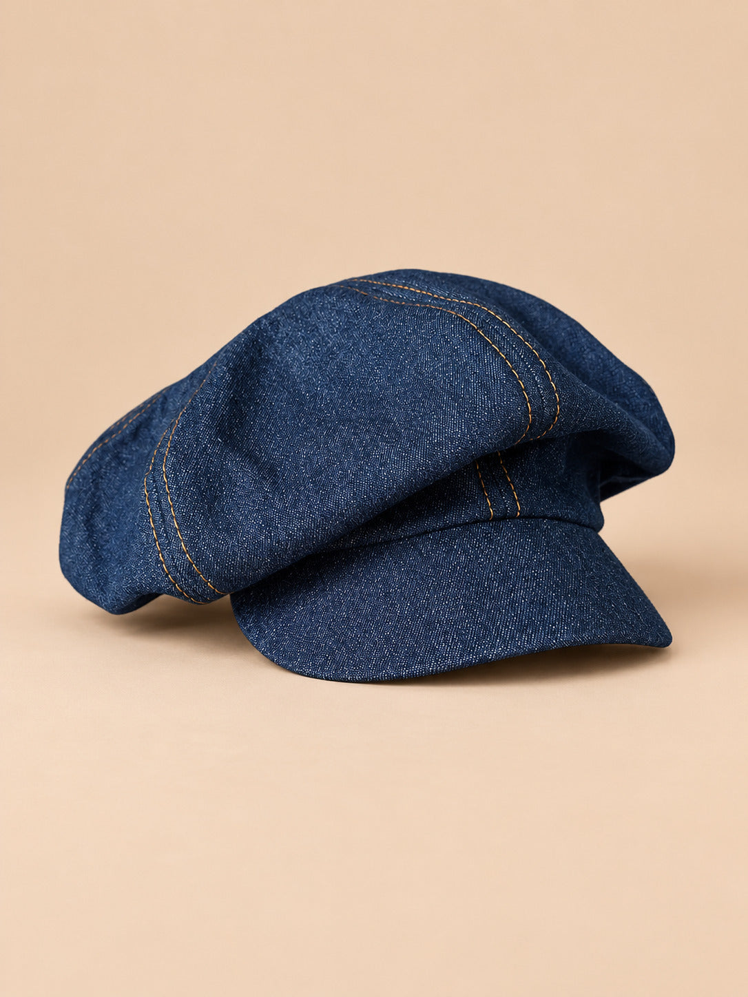 Casquette gavroche vintage gris, vue de face sur fond pêche sable