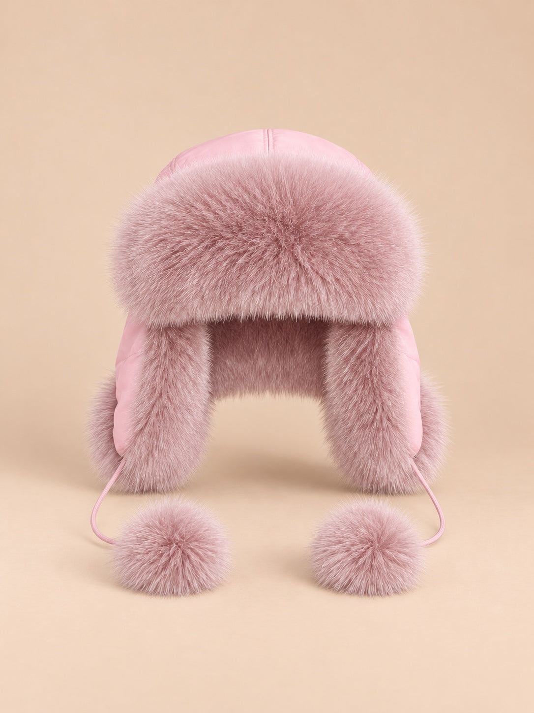 Chapka femme en fourrure à pompons beige rosé, vue de face.