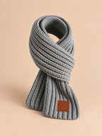 Écharpe enfant en maille côtelée à étiquette gris, vue de trois quarts.