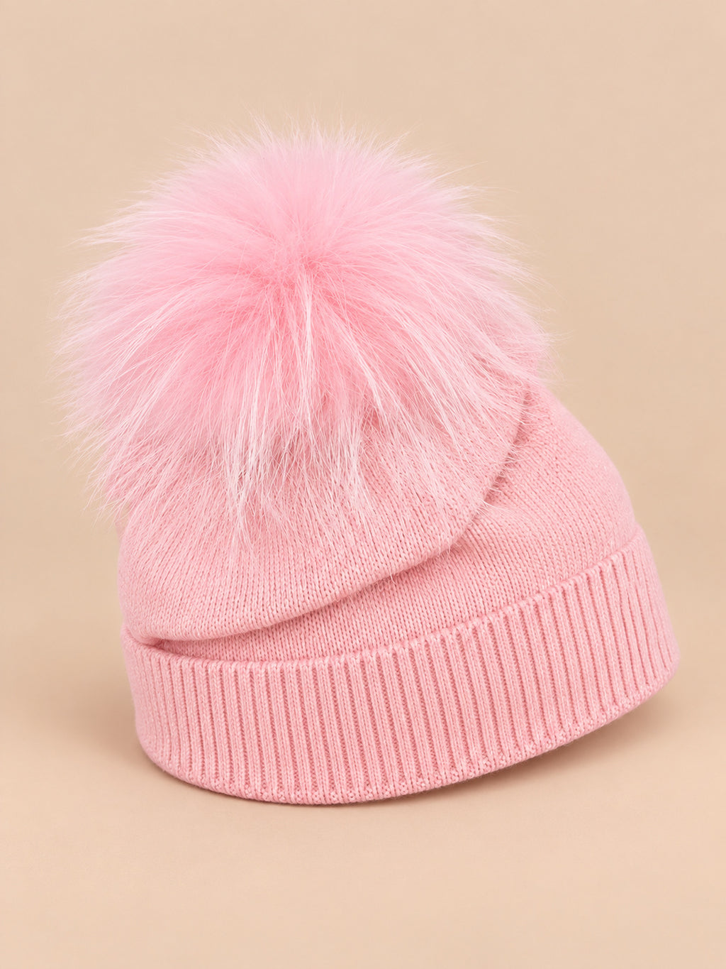Bonnet enfant rose pompon assorti en maille à revers, vue de trois quarts