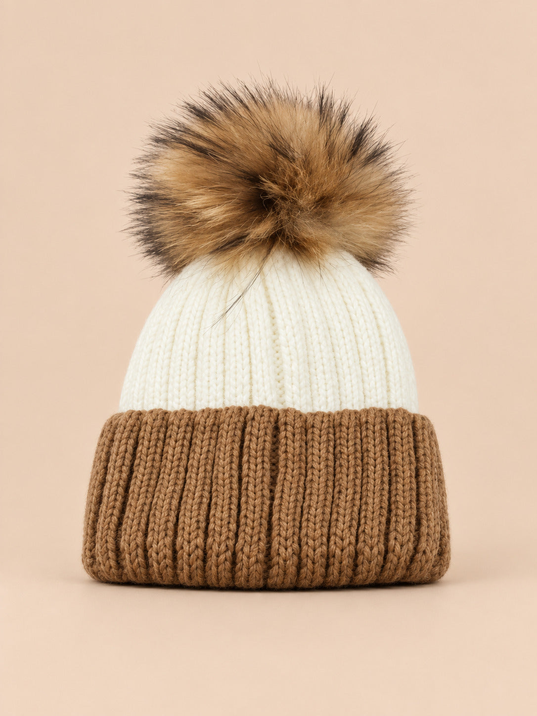 Bonnet enfant à pompon blanc 3, vue de face sur fond pêche sable