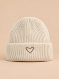 Bonnet enfant beige en maille, vue de face, fond pêche sable