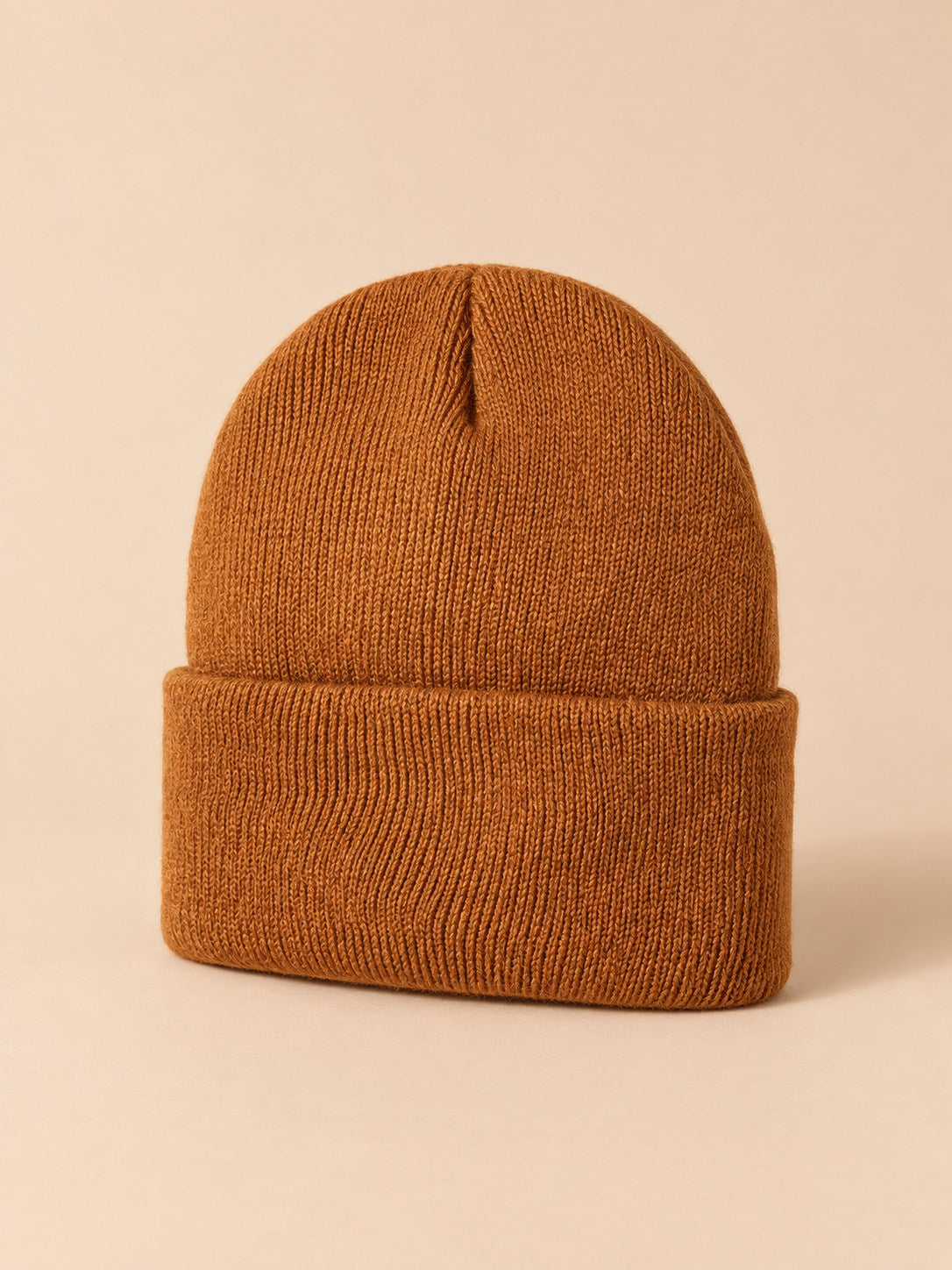 Bonnet enfant caramel en maille, vue de trois quarts, fond pêche sable
