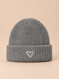 Bonnet enfant gris en maille, vue de face, fond pêche sable