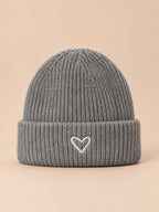 Bonnet enfant gris en maille, vue de face, fond pêche sable