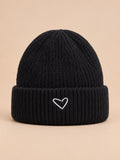 Bonnet enfant noir en maille, vue de face, fond pêche sable