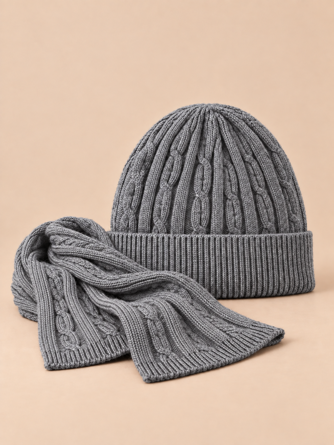 Ensemble bonnet à revers et écharpe en laine jacquard grise, vue de face sur fond pêche sable.