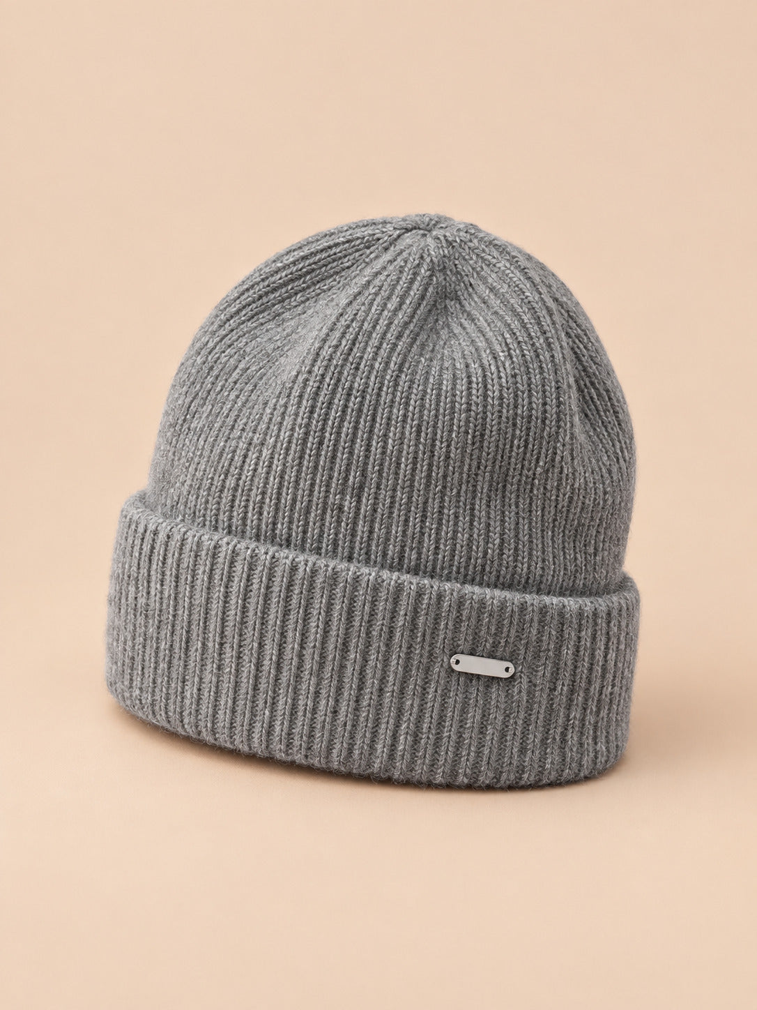 Bonnet côtelé en laine mélangée, coloris 1 gris, vue de trois quarts sur fond pêche sable
