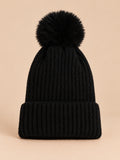 Bonnet de ski noir sans logo à gros pompon assorti et revers côtelé, vue de face.