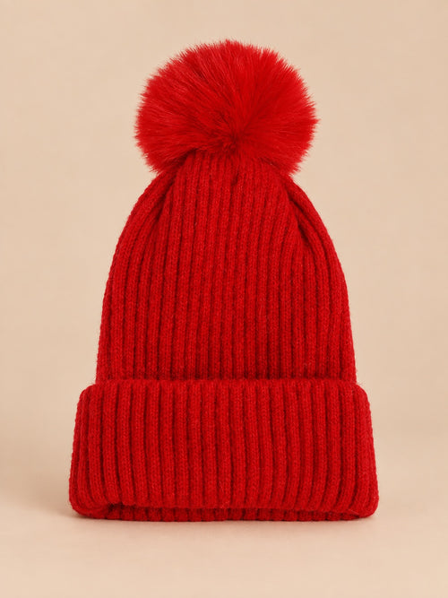 Bonnet de ski rouge sans logo, maille côtelée à revers et gros pompon assorti, vue de face.