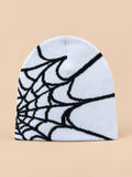 Bonnet motif toile d'araignée blanc à toile noire, vue de face sur fond pêche sable