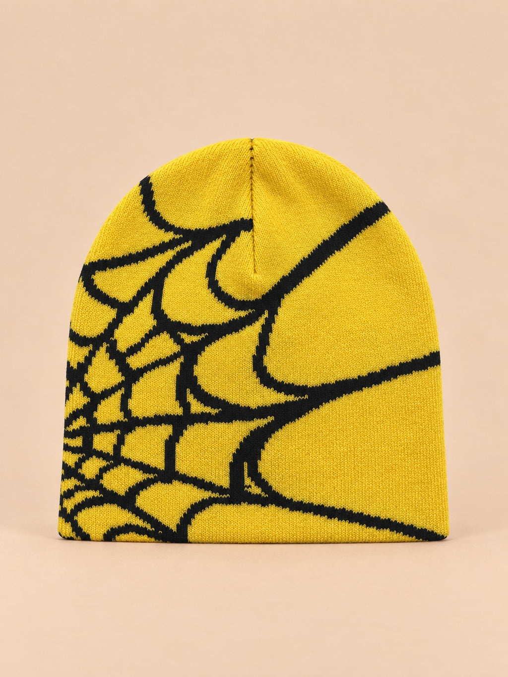 Bonnet motif toile d'araignée jaune et noir, vue de face sur fond pêche sable