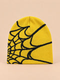 Bonnet motif toile d'araignée jaune et noir, vue de face sur fond pêche sable