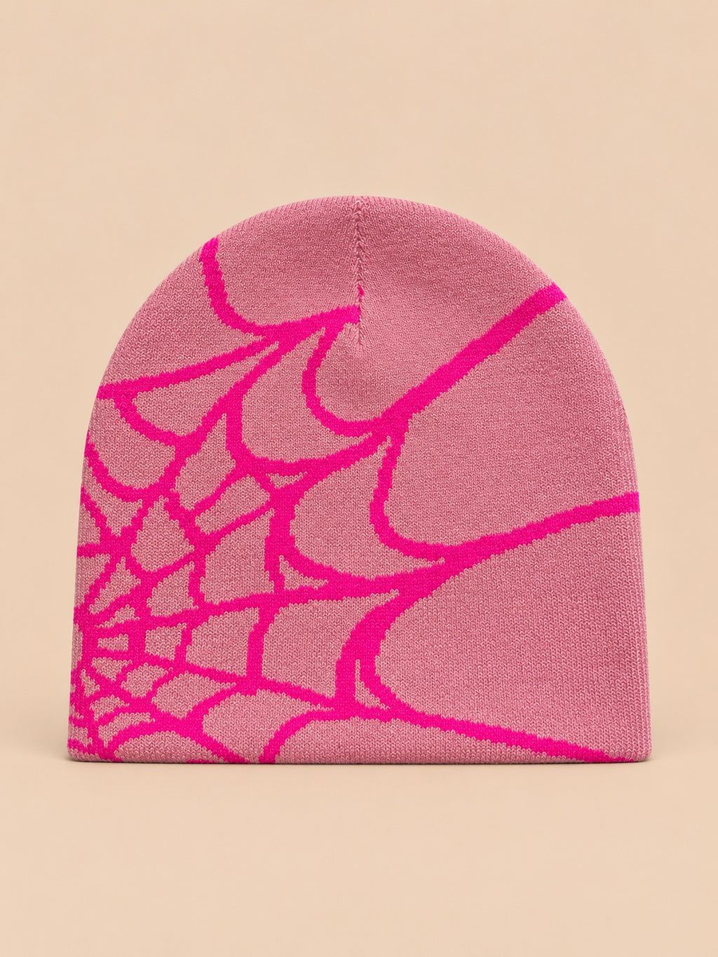 Bonnet motif toile d'araignée rose à toile fuchsia, vue de face sur fond pêche sable