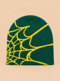 Bonnet motif toile d'araignée vert à toile jaune, vue de face sur fond pêche sable