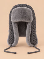 Bonnet péruvien à cache-oreilles gris, vue de face sur fond pêche sable