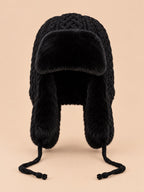 Bonnet péruvien à cache-oreilles noir, vue de face sur fond pêche sable