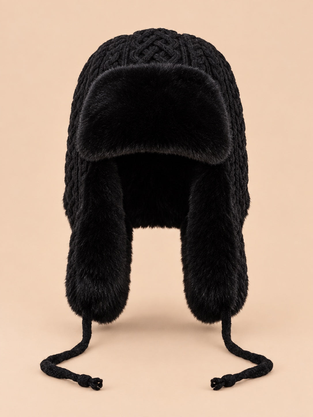 Bonnet péruvien à cache-oreilles noir, vue de face sur fond pêche sable