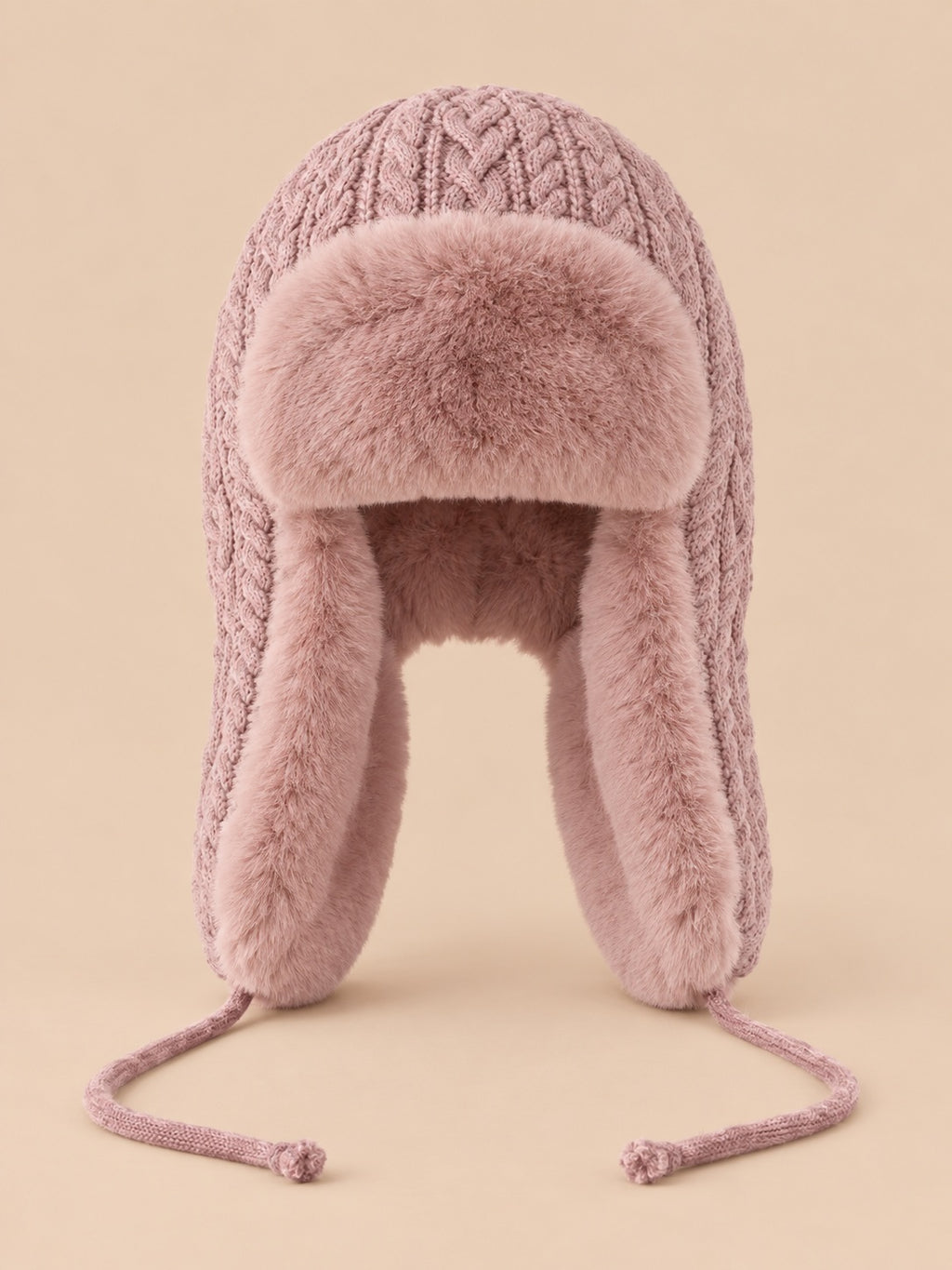 Bonnet péruvien à cache-oreilles rose poudré, vue de face sur fond pêche sable