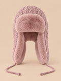 Bonnet péruvien à cache-oreilles rose poudré, vue de face sur fond pêche sable