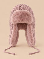 Bonnet péruvien à cache-oreilles rose poudré, vue de face sur fond pêche sable