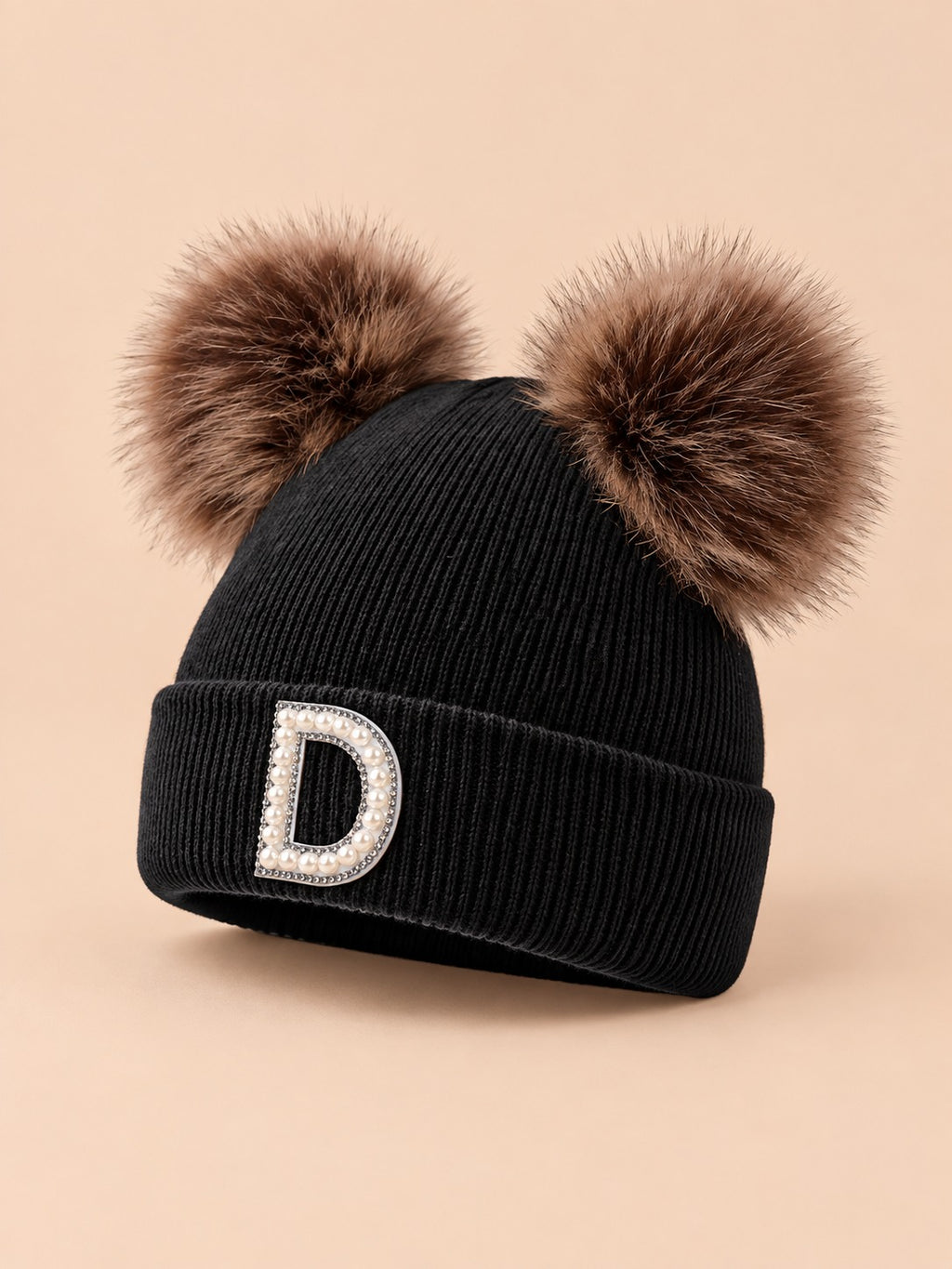 Bonnet polaire femme noir à oreilles, lettre D, vue de trois quarts sur fond beige