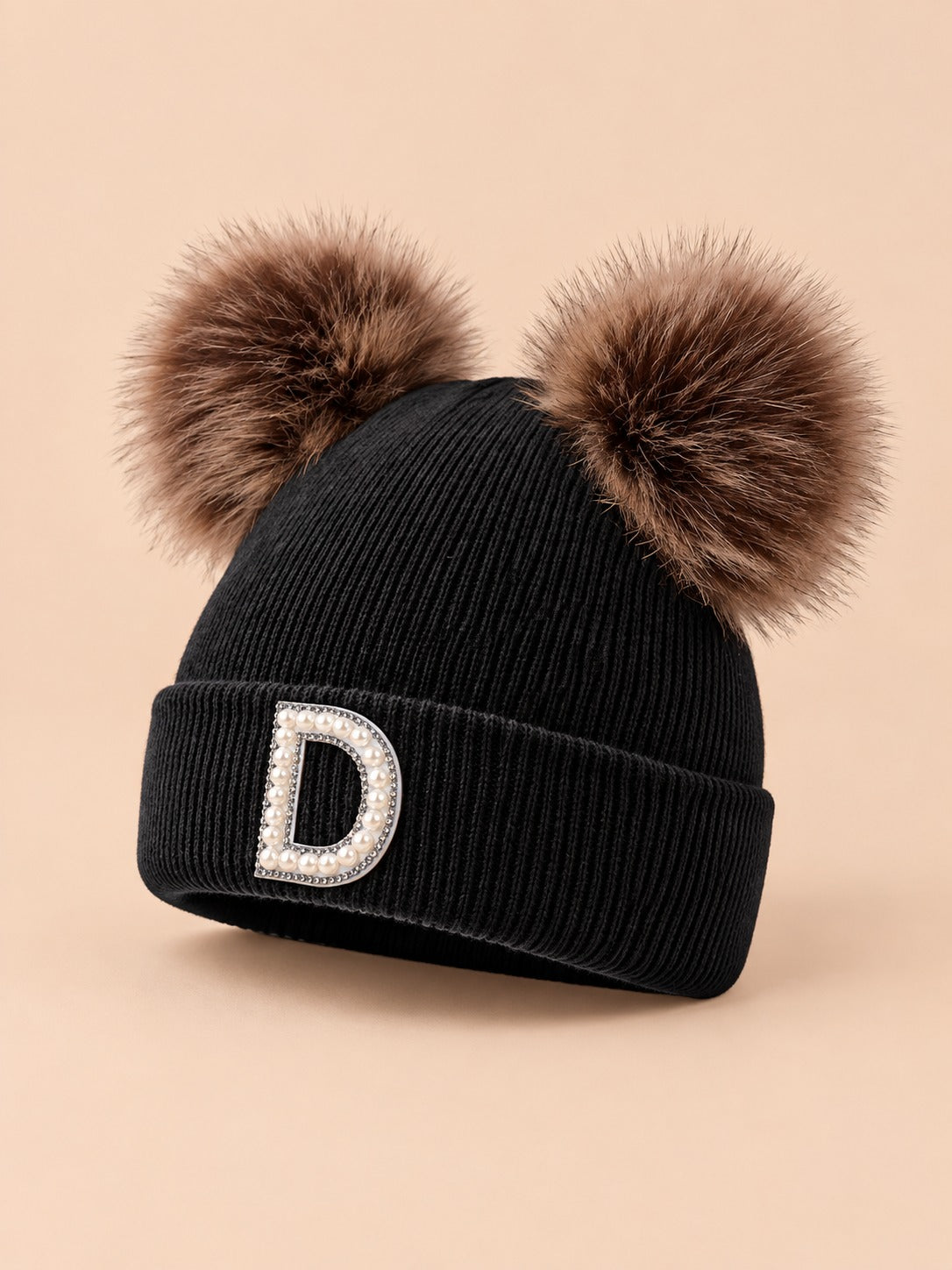 Bonnet polaire femme noir à oreilles, lettre D, vue de trois quarts sur fond beige