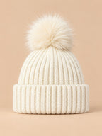 Bonnet à pompon blanc en maille côtelée à revers, vue de face.