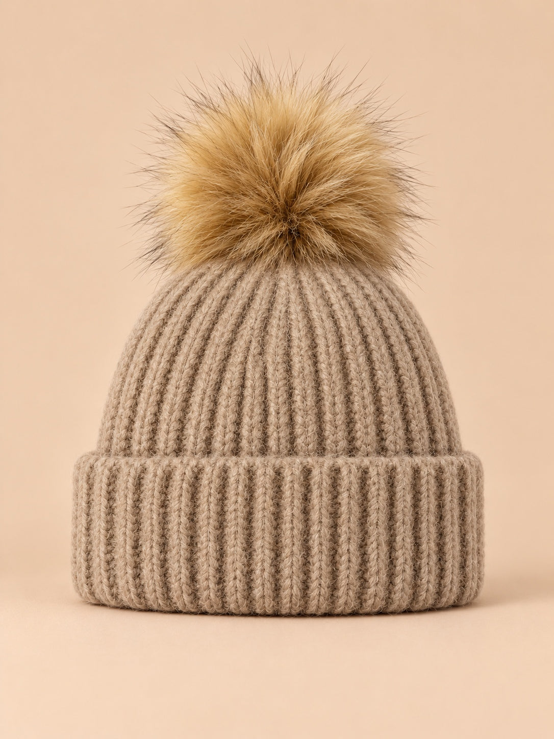 Bonnet à pompon marron foncé en maille côtelée à revers, vue de face.
