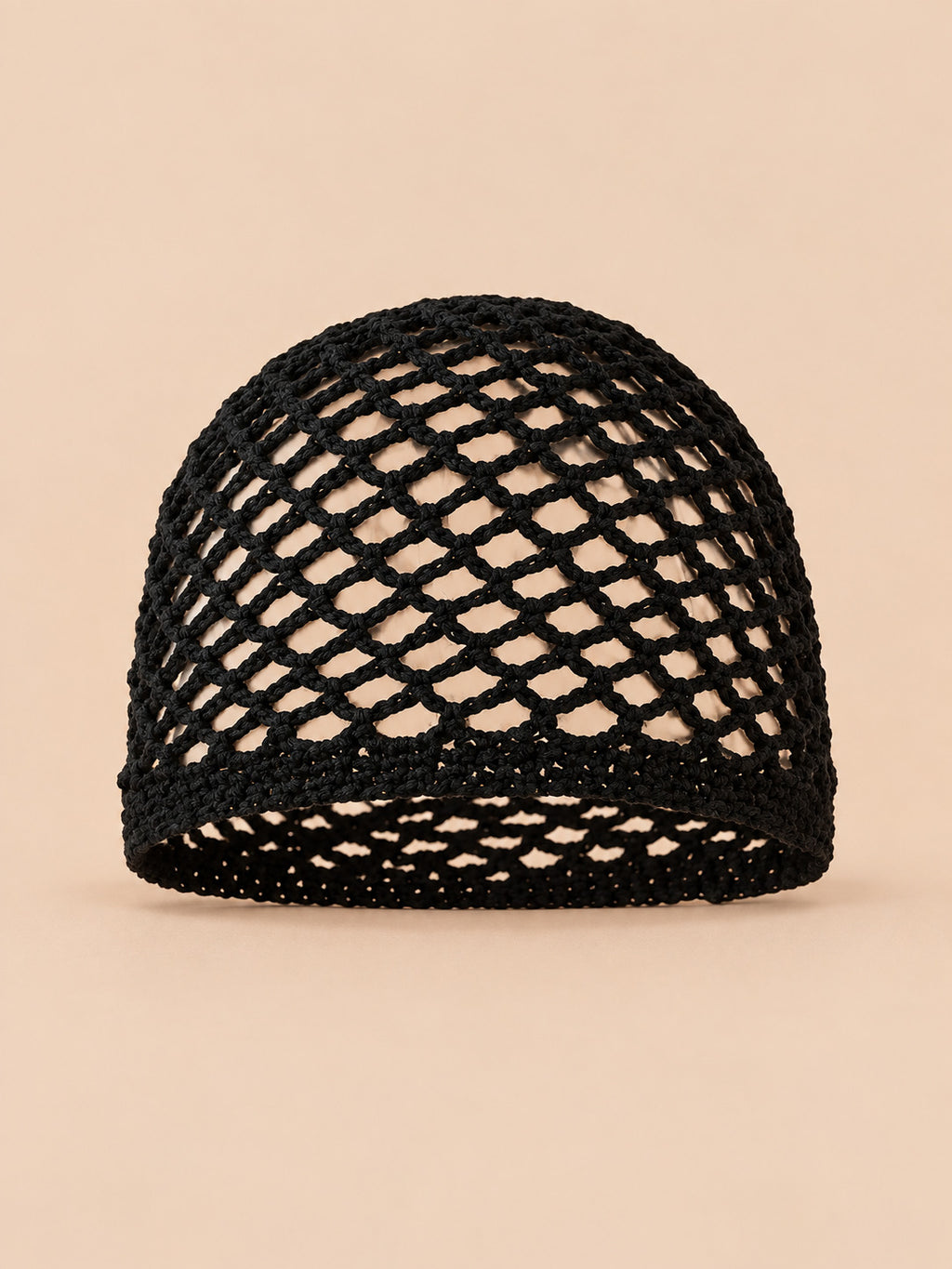 Bonnet fin femme noir en coton résille ajouré, vue de face sur fond pêche sable