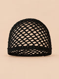 Bonnet fin femme noir en coton résille ajouré, vue de face sur fond pêche sable