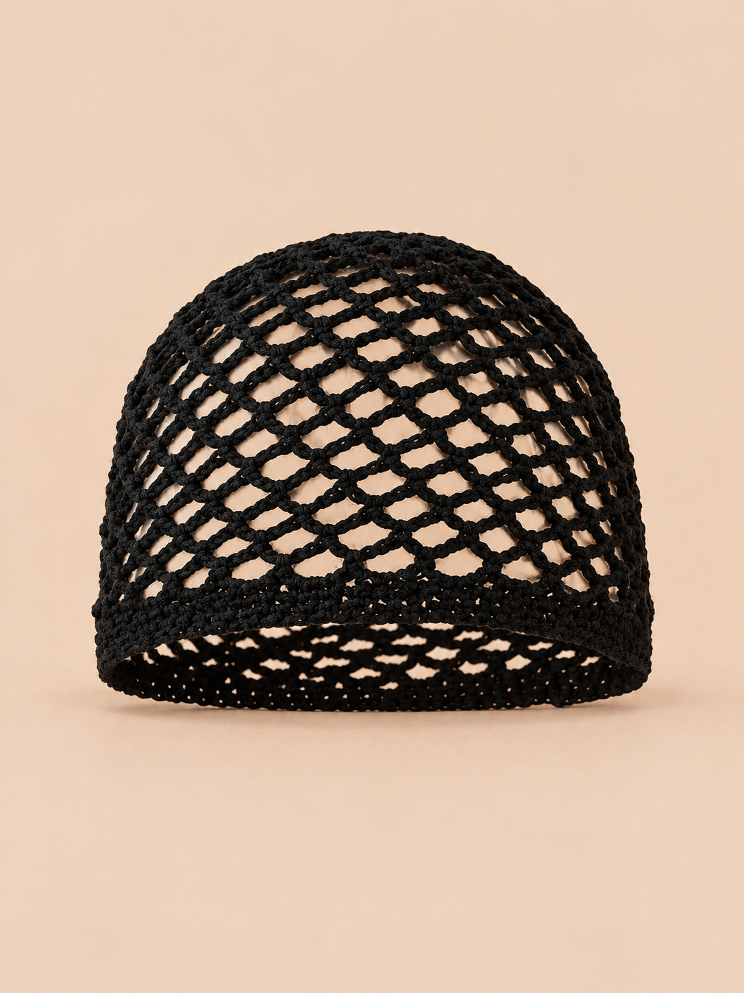 Bonnet fin femme noir en coton résille ajouré, vue de face sur fond pêche sable