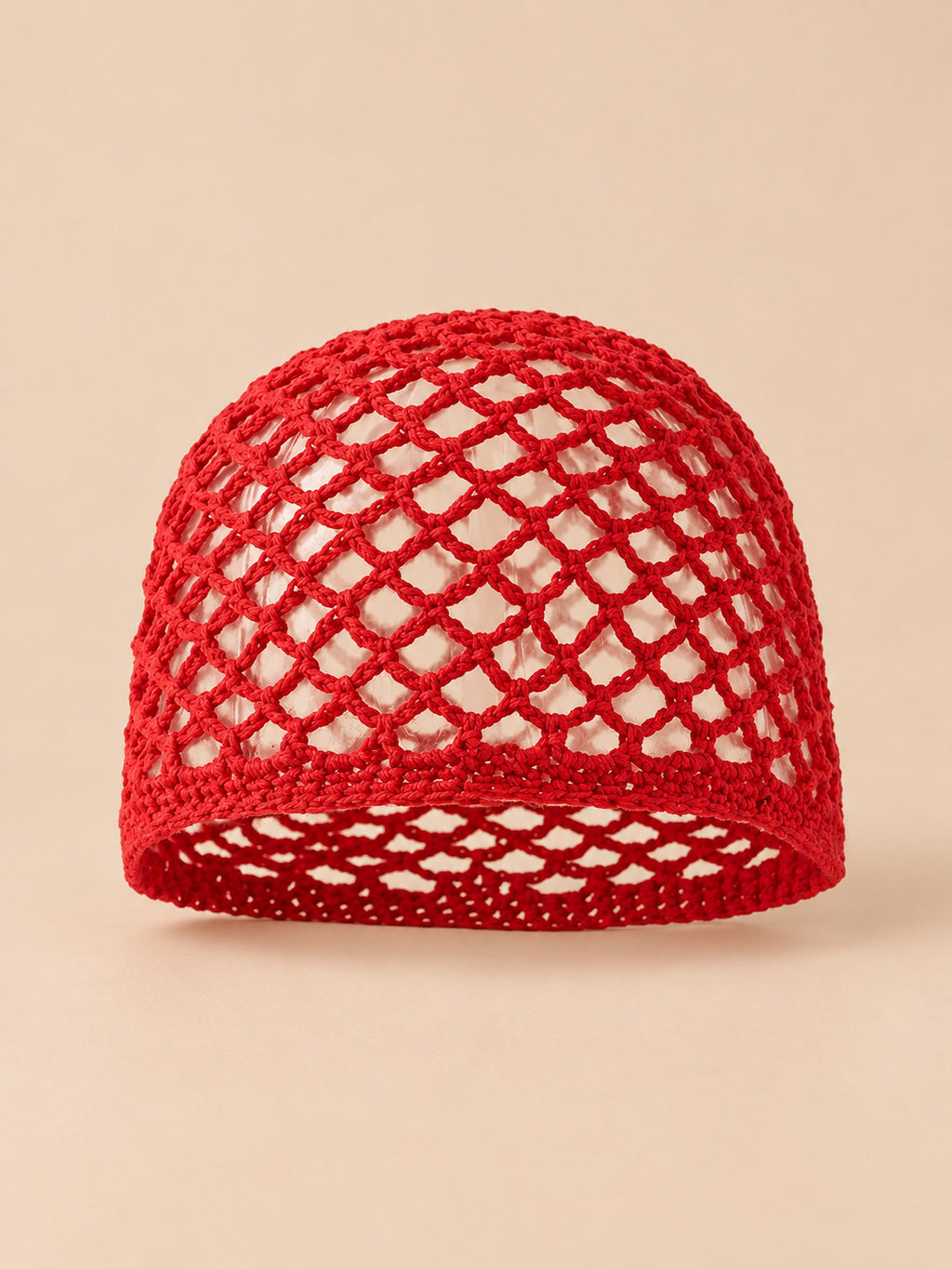 Bonnet fin femme rouge en coton résille ajouré, vue de face sur fond pêche sable