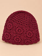 Bonnet turban femme bordeaux ajouré à fleurs au crochet, vue de face sur fond pêche sable