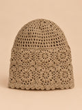 Bonnet turban femme kaki ajouré à fleurs au crochet, vue de face sur fond pêche sable