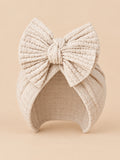Bonnet turban bébé fille en coton tricoté beige clair, nœud, vue de face