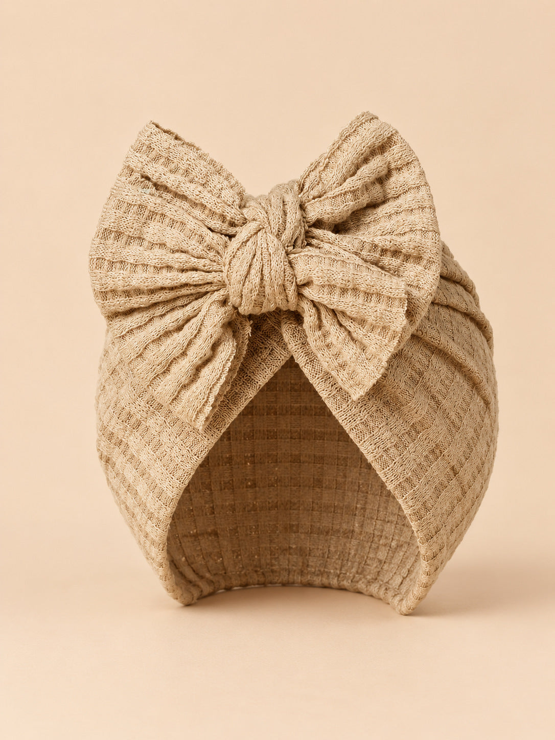 Bonnet turban bébé fille en coton tricoté beige sable, nœud, vue de face
